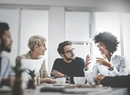 Eine Gruppe von Wirtschaftspsychologen und -psychologinnen sprechen in einem Meeting.