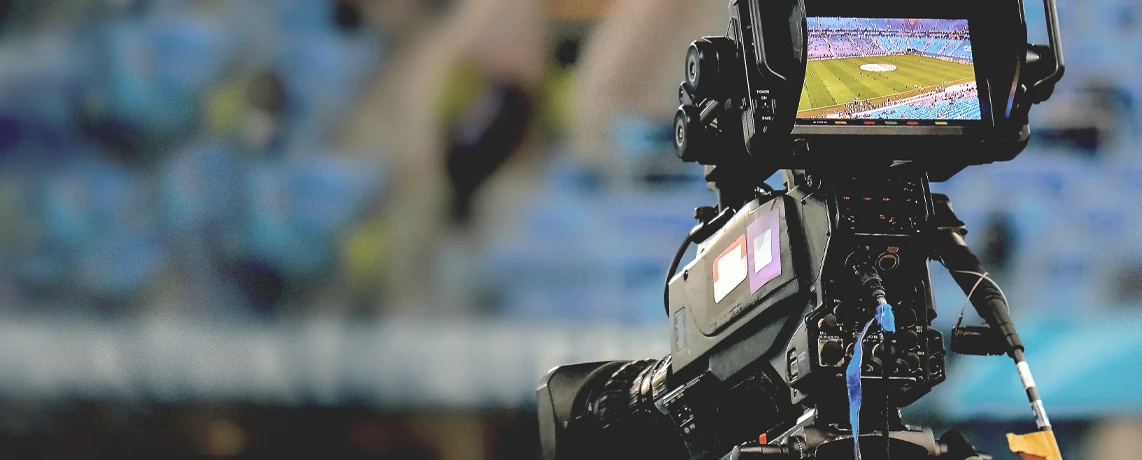 Eine Filmkamera ist auf ein Fußballfeld gerichtet.