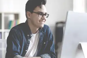 Junger BWL-Student schreibt an einer Abschlussarbeit im Bereich Wirtschaftsprüfung.