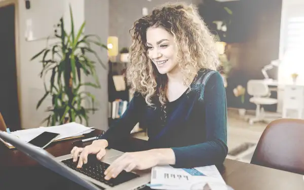 Eine junge Frau recherchiert am Laptop über Weiterbildungen im sozialen Bereich. 