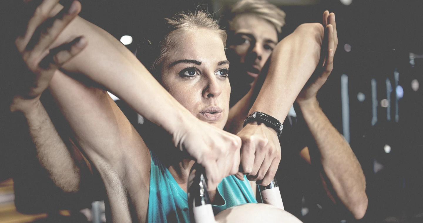 Ein Physiotherapeut unterstützt eine Sportlerin bei Übungen mit einer Kettle Bell.