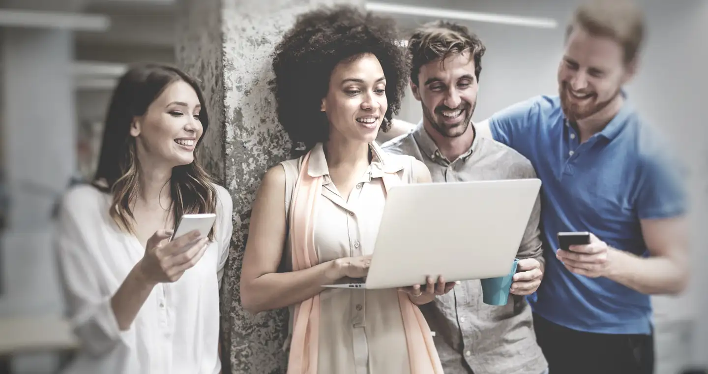 Personalmanagement Team schaut auf den Laptop und unterhält sich amüsiert