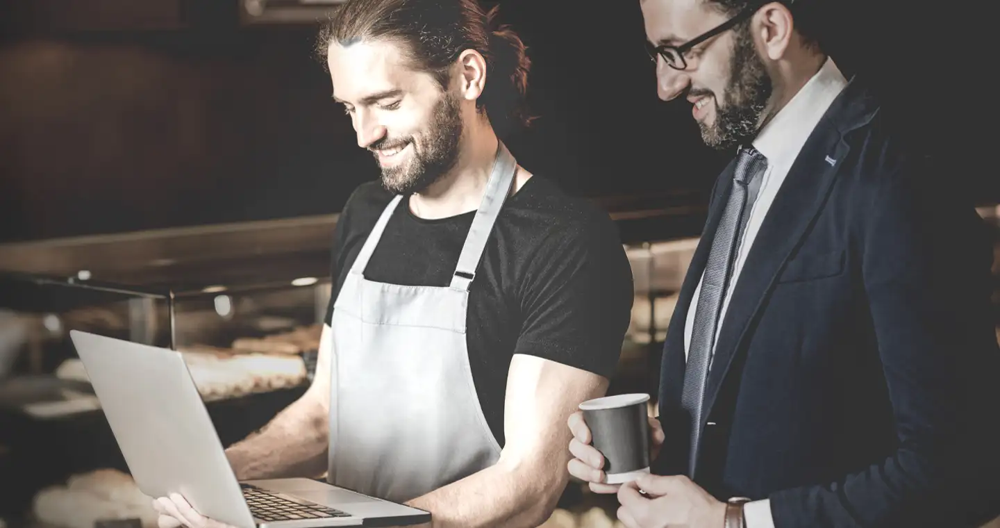 Personalmanager schaut mit dem Restaurantleiter auf den Laptop