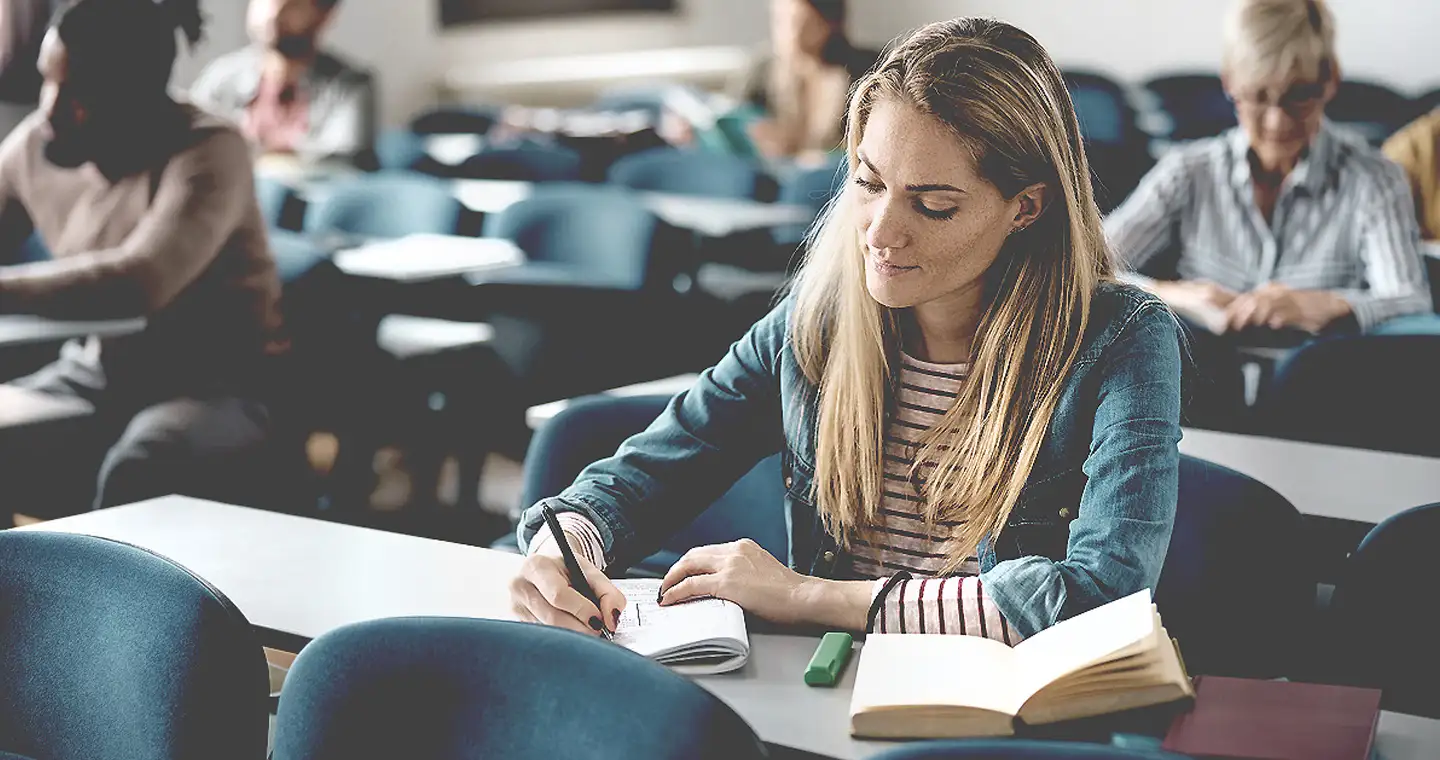 Junge Studentin  sitzt in einem Seminar für Bilanzen & Finance.