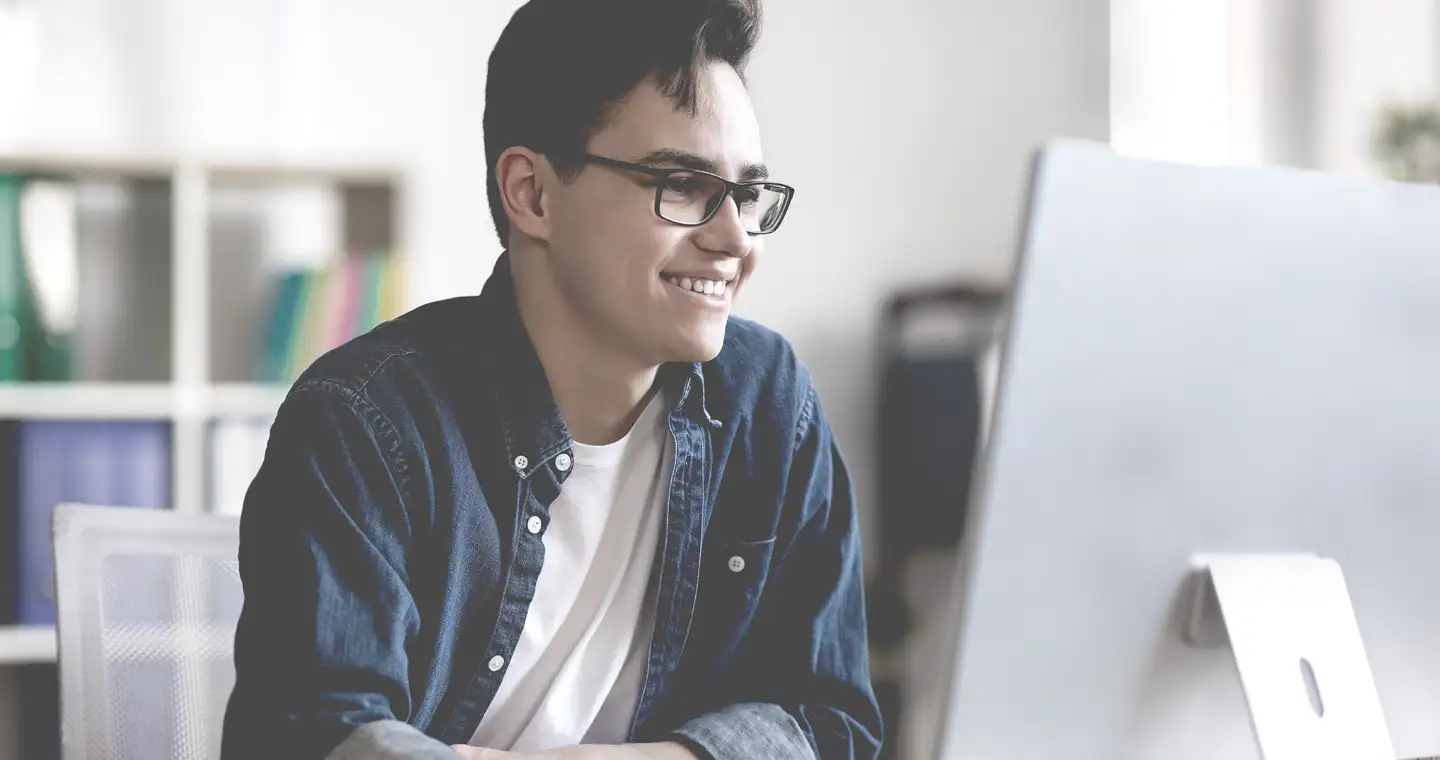 Junger BWL-Student schreibt an einer Abschlussarbeit im Bereich Wirtschaftsprüfung.