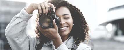 Eine junge Sportmarketing Studentin macht ein Foto mit ihrer Kamera