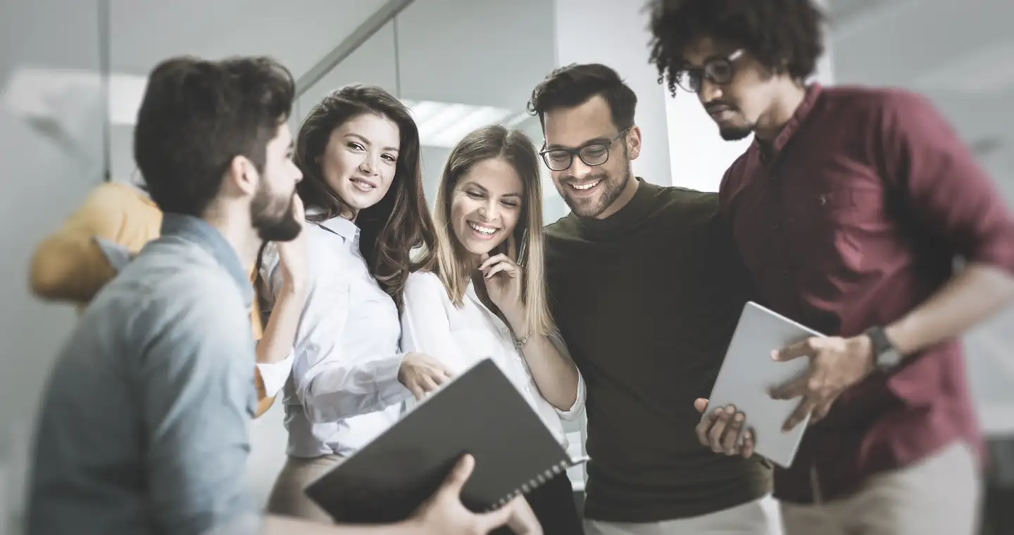 Ein Team junger Wirtschaftspsycholog*innen berät sich im Büro.