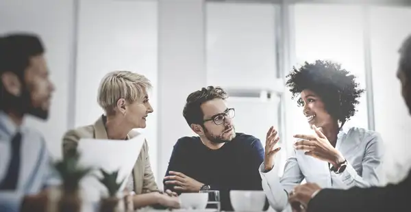 Eine Gruppe von Wirtschaftspsychologen und -psychologinnen sprechen in einem Meeting.