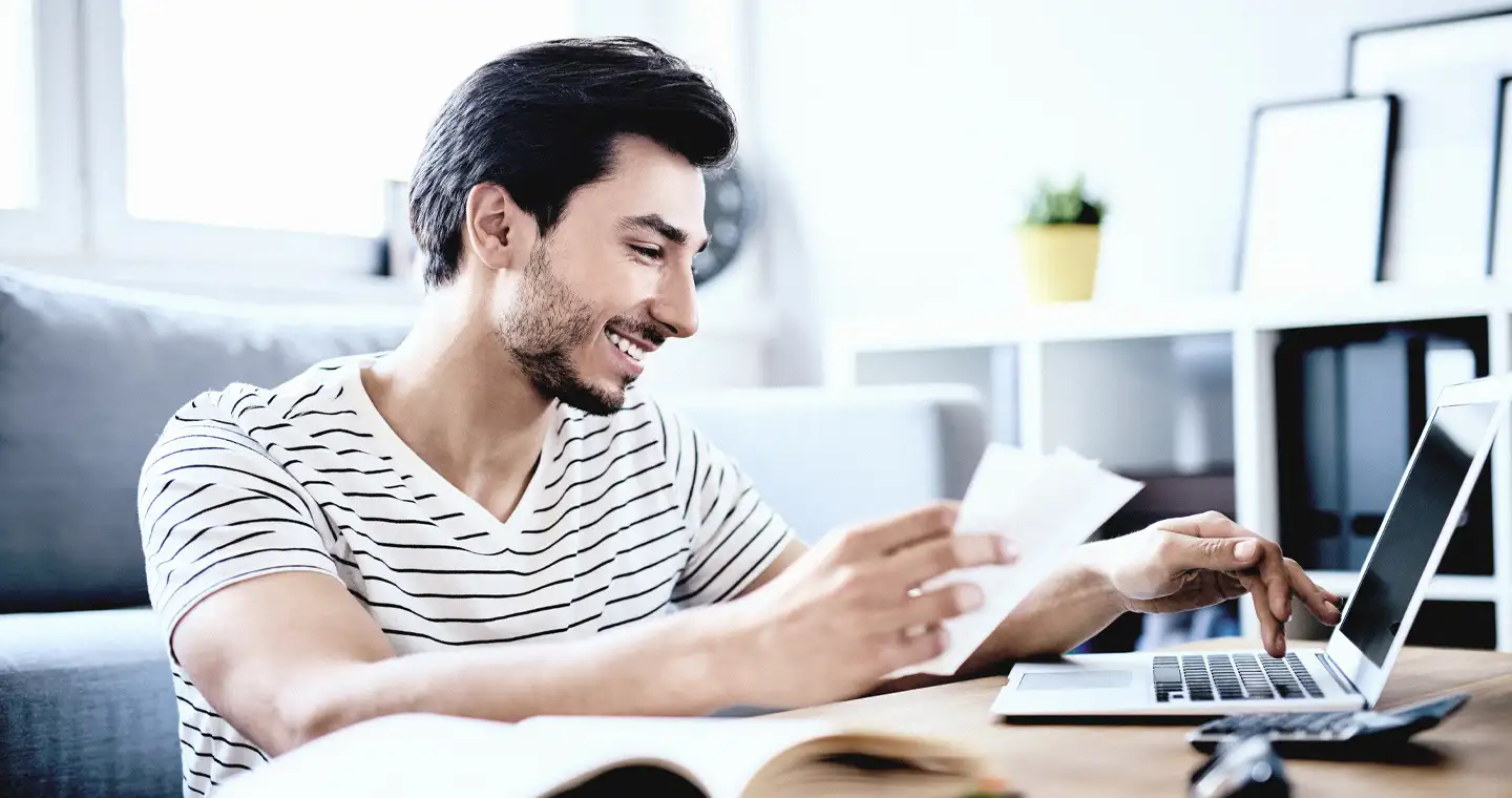 Mann sucht nach Informationen über Studienkredite an seinem Laptop.