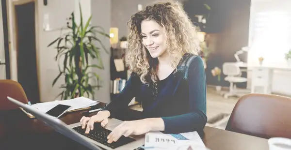 Eine junge Frau recherchiert am Laptop über Weiterbildungen im sozialen Bereich. 