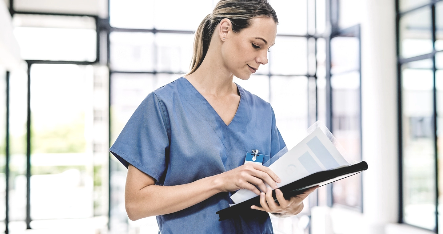 Pflegewissenschaftlerin mit einer Patientenakte.