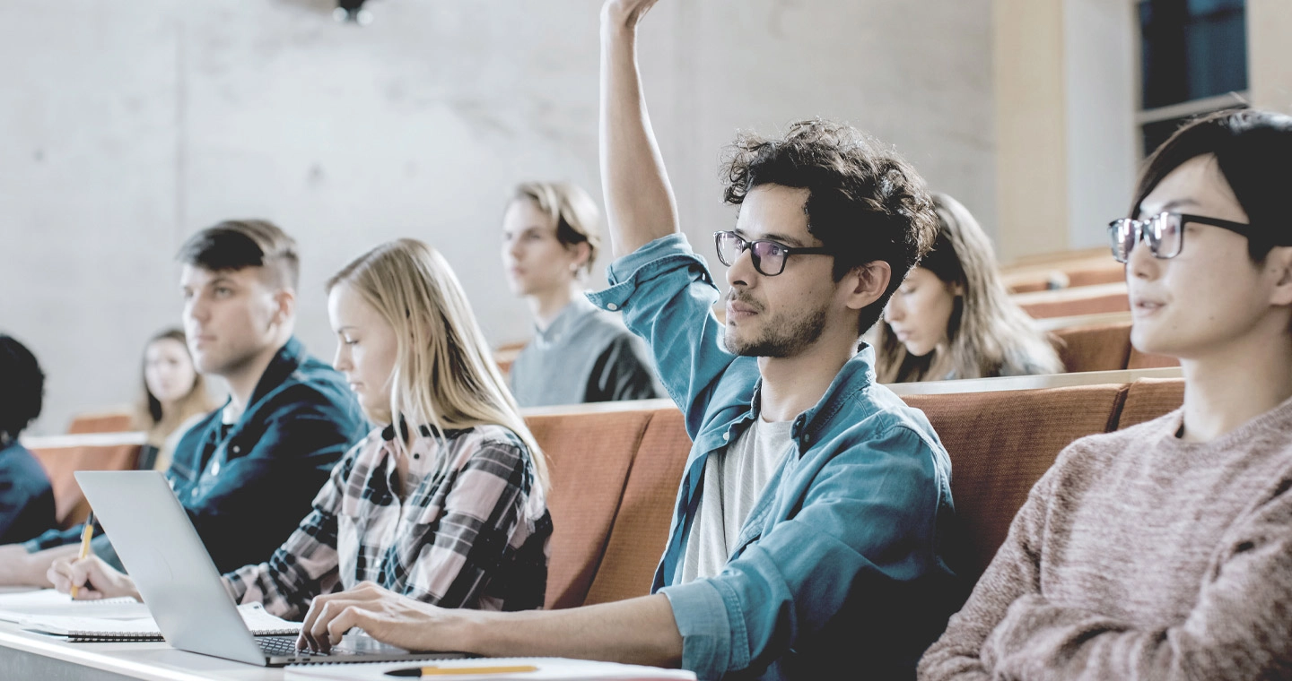 Student*innen lernen gemeinsam in einem Hörsaal.