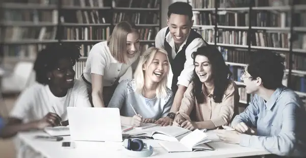 Eine Gruppe Studierender lernt gemeinsam für das Steuerberaterexamen in einer Hochschulbibliothek.