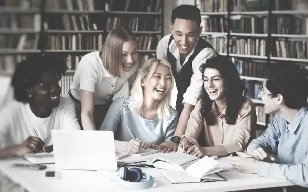 Eine Gruppe Studierender lernt gemeinsam für das Steuerberaterexamen in einer Hochschulbibliothek.