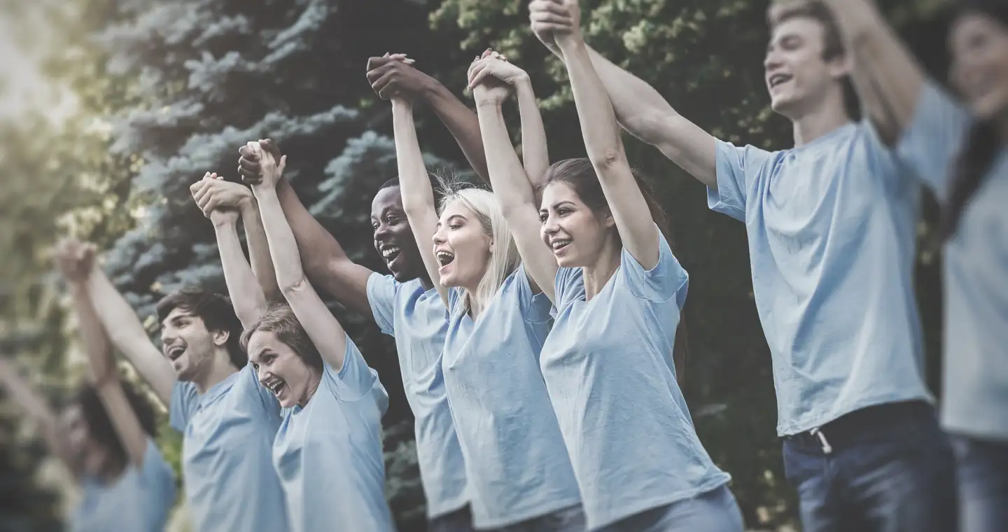 Eine Gruppe von Studierenden im sozialen Bereich freut sich. Sie halten sich an den Händen.