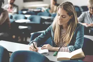 Junge Studentin  sitzt in einem Seminar für Bilanzen & Finance.