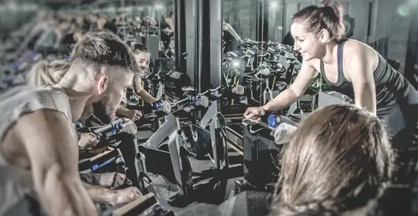 Gruppen-Trainerin gemeinsam mit ihren Kund*innen beim Cycle-Training.