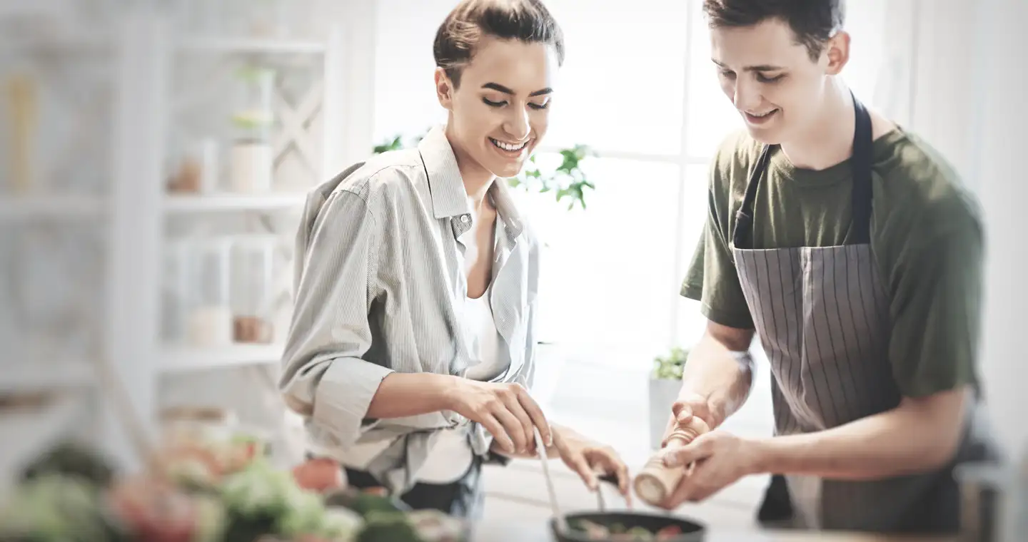 Zwei Ernährungsberater sprechen beim Kochen über die Kosten ihrer Ausbildung. 