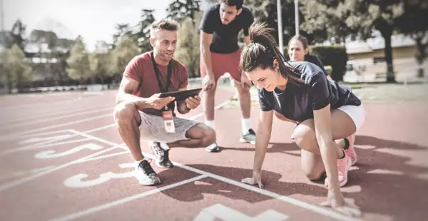 Läufer*innen zusammen mit ihrem Athletiktrainer.