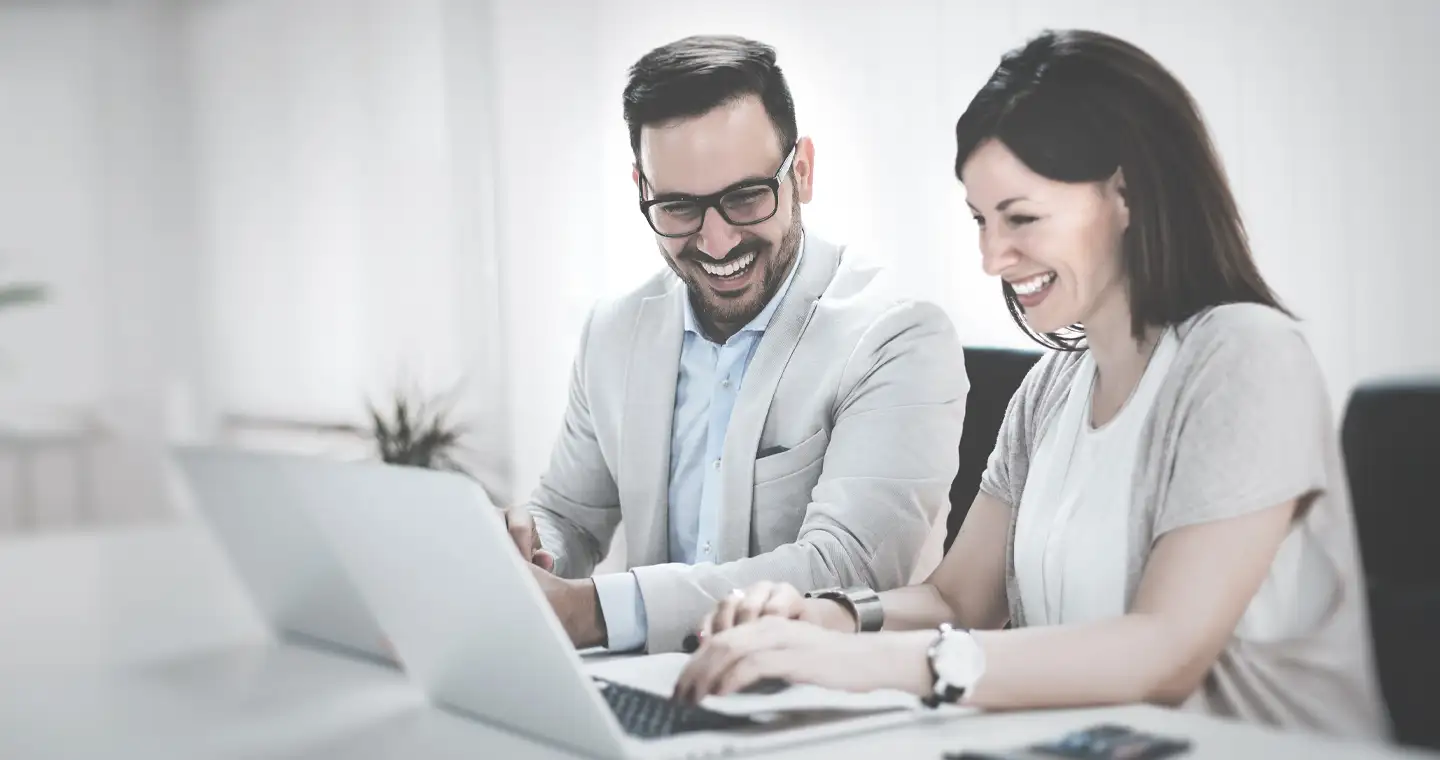 Steuerberater*innen besprechen sich gemeinsam und gleichen ihre Ergebnisse an ihrem Computern ab.