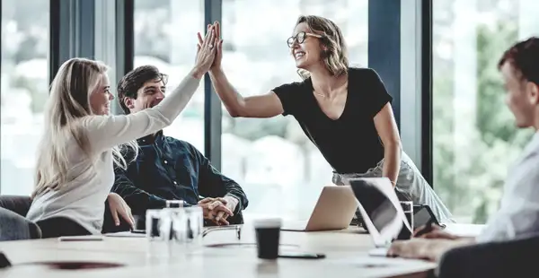 Personalleiterinnen klatschen nach einem erfolgreichen Meeting ab