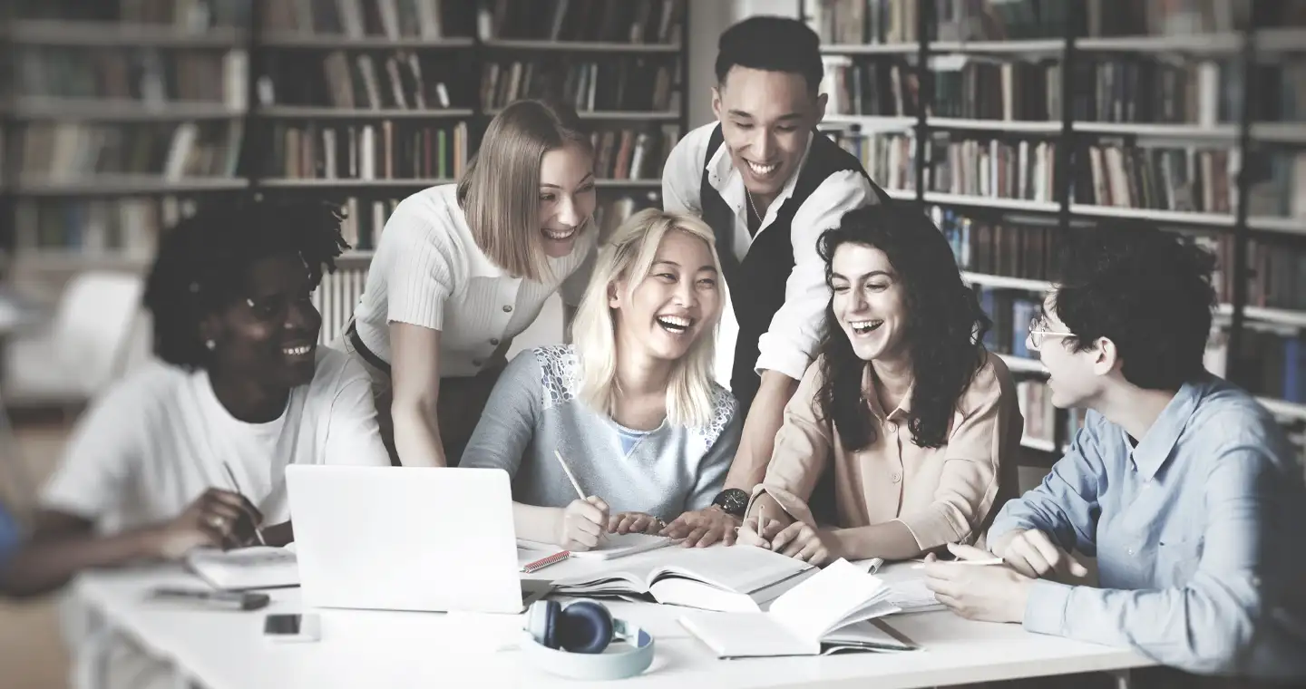 Eine Gruppe Studierender lernt gemeinsam in einer Bibliothek für das Steuerberaterexamen.