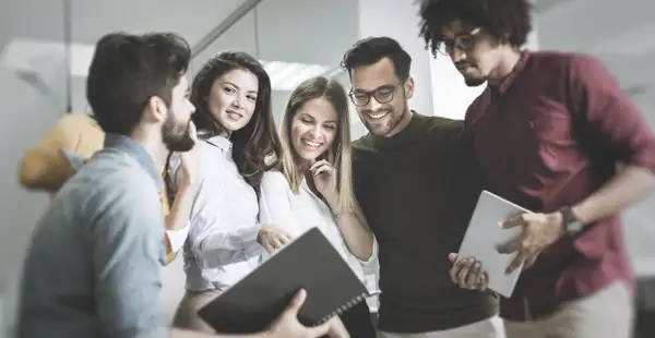 Ein Team junger Wirtschaftspsycholog*innen berät sich im Büro.