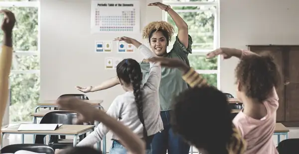 Eine Inklusionspädagogin leitet eine Gruppe von Kindern in einem Klassenzimmer bei einer gemeinsamen Aktivität an.