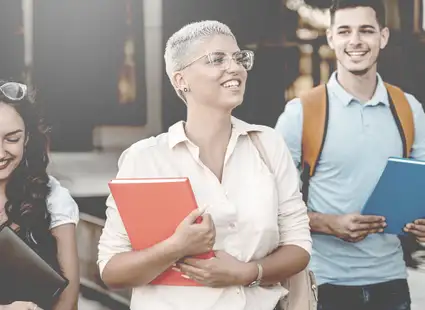 Studierende halten ihre Unterlagen in den Händen, während sie das Unigebäude verlassen.