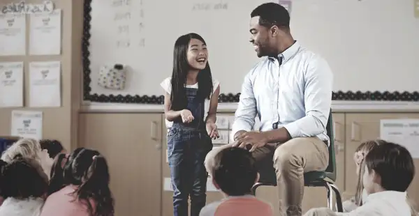 Ein Erziehungswissenschaftler spricht mit Kindern.