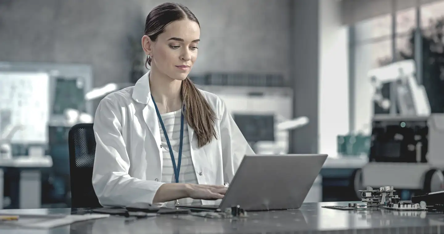 Eine Sportwissenschaftlerin dokumentiert Ergebnisse eines Tests an ihrem Laptop in einem Labor.