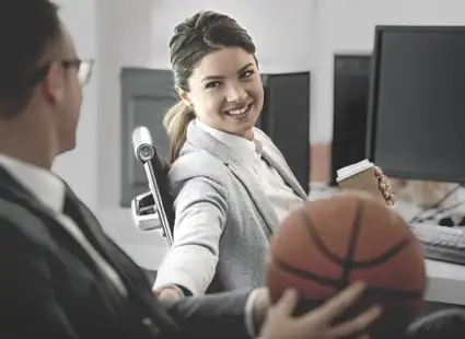 Sportmanager unterhält sich mit Kollegin im Büro.